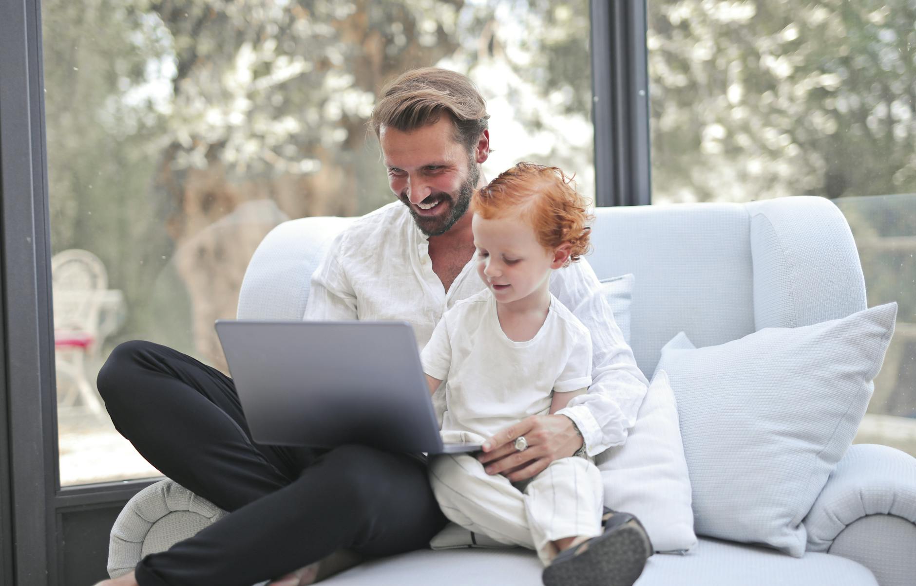 smiling dad and son using a laptop together