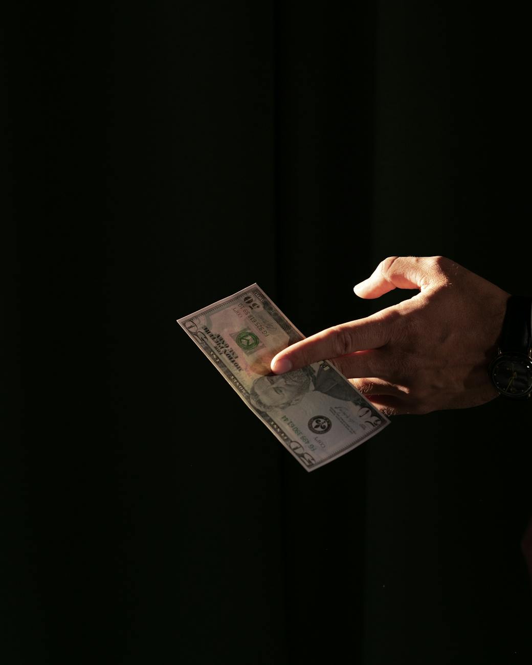 a person holding a dollar bill