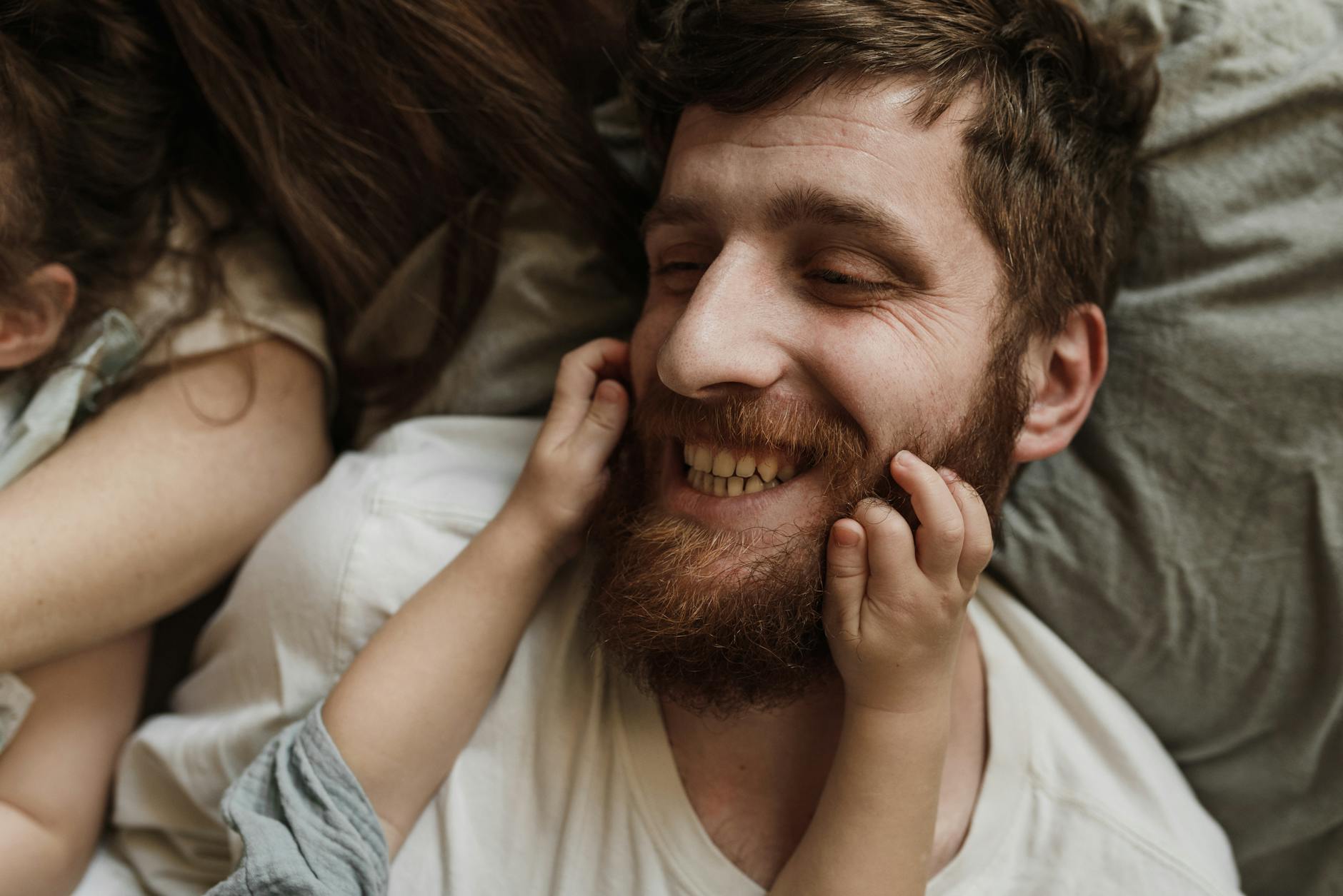 a child holding the fathers beard